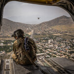 An American soldier aboard a Chinook helicopter over Kabul, Afghanistan, on Sunday.